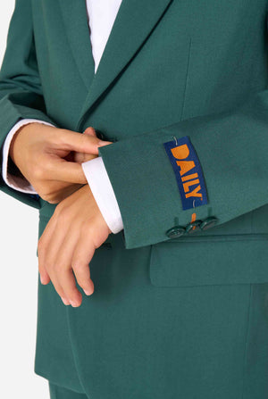 Kind trägt einen stilvollen dunkelgrünen Anzug mit weißem Hemd, schaut weg von der Kamera. Perfektes festliches Outfit für besondere Anlässe, Hochzeiten und Partys von Jungen. Nahaufnahme des Ärmels.