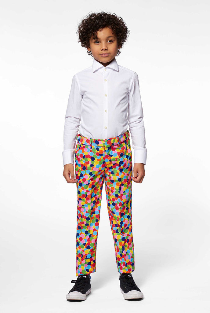 Junge, der mehrfarbige Konfetti -Druckhosen Teil des Jungenanzugs trägt