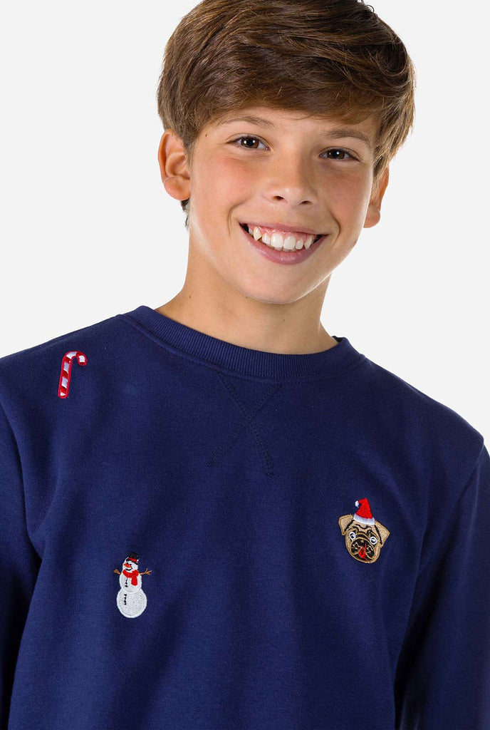 Kind trägt blauen Weihnachtspullover mit Weihnachtselikonen, Nahaufnahme