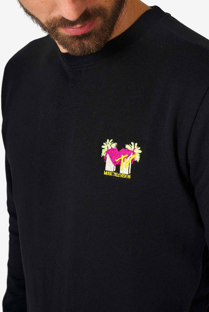 Mann, der einen schwarzen Pullover mit MTV -Stickerei trägt, Nahaufnahme