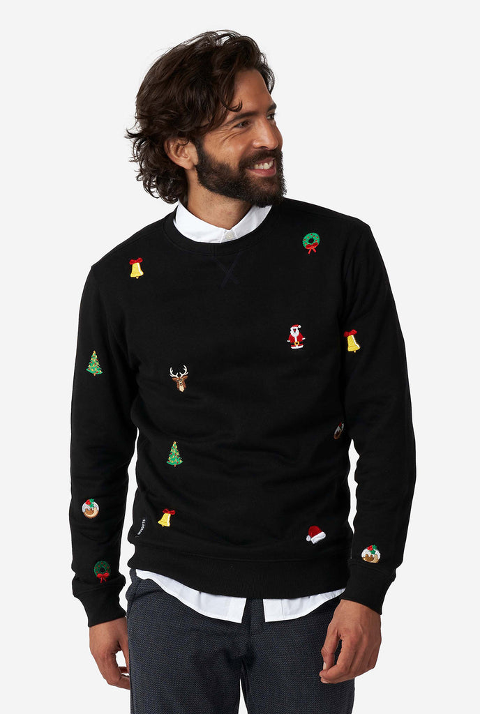 Mann, der schwarzen Weihnachtspullover mit Weihnachtsikonen trägt