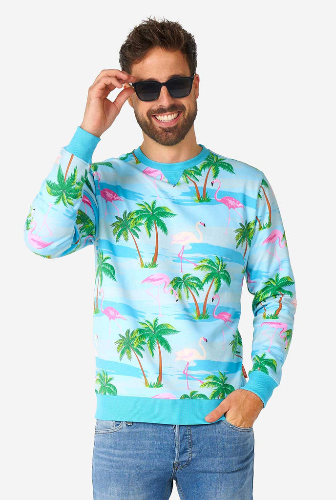 Mann, der blauen Pullover mit tropischem Flamingo -Druck trägt
