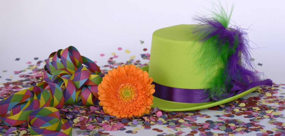 Image of green hat, confetti and orange flower. 