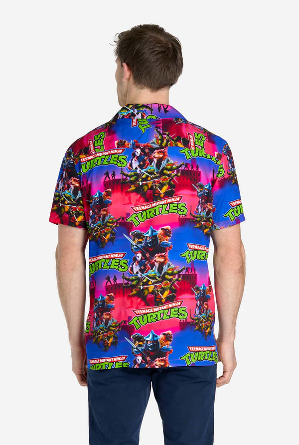 Mann trägt Hawaiihemd mit Teenage Mutant Ninja Turtles-Aufdruck. Ansicht von hinten.