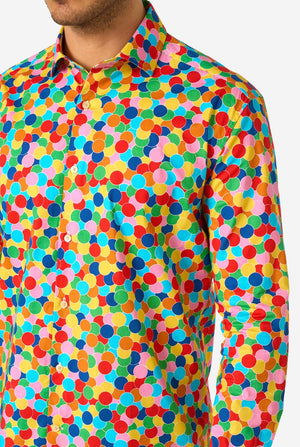 Person, die ein buntes, gepunktetes Konfetti-Shirt mit einfarbigem Hintergrund trägt, Nahaufnahme.