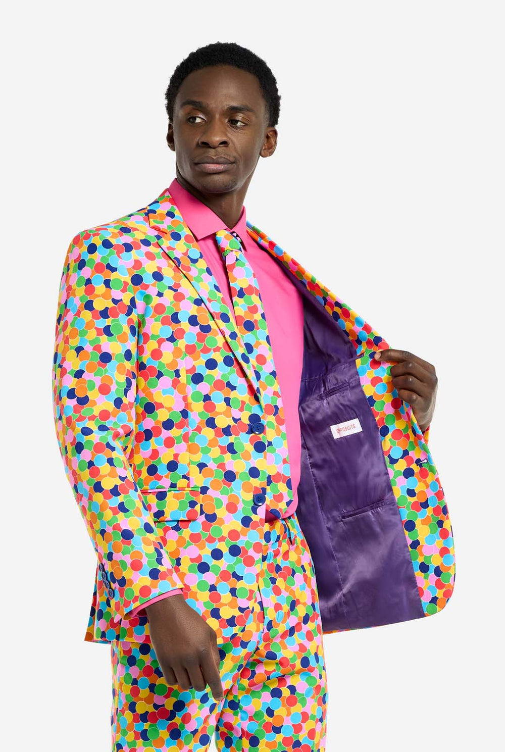 Bild eines Mannes, der einen OppoSuits Confetteroni-Herrenanzug mit Konfetti-Aufdruck und rosa Herrenhemd trägt. Der Anzug besteht aus Hose, Jacke und Krawatte.