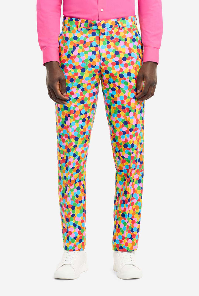 Bild eines Mannes, der einen OppoSuits Confetteroni-Herrenanzug mit Konfetti-Aufdruck und rosa Herrenhemd trägt. Der Anzug besteht aus Hose, Jacke und Krawatte.