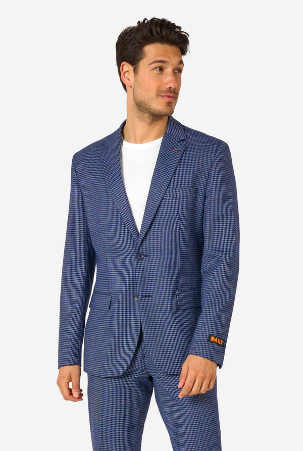 Ein Mann, der einen dunkelblau-blau karierten Anzug mit einem weißen Hemd trägt. Der Anzug hat eine moderne Passform mit zwei Knöpfen und Pattentaschen. Er steht vor einem schlichten weißen Hintergrund.