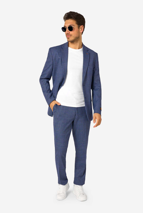 Ein Mann, der einen dunkelblau-blau karierten Anzug mit einem weißen Hemd trägt. Der Anzug hat eine moderne Passform mit zwei Knöpfen und Pattentaschen. Er steht vor einem schlichten weißen Hintergrund. Ganzkörperbild
