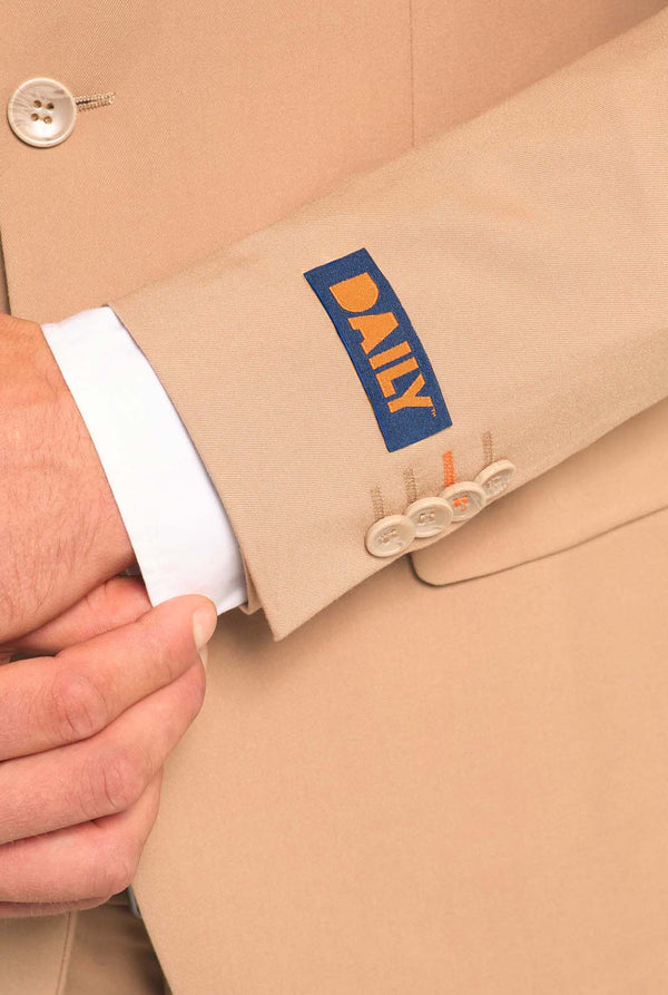 Bild mit hellgrauem Hintergrund und Mann trägt Dark Sand Herrenanzug und weißes Hemd. Anzüge besteht aus Blazer und Hose. Konzentriert sich auf die Ärmel.