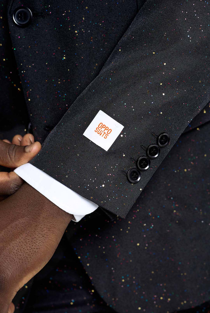 Bild eines Mannes, der einen OppoSuits Glitzy Glitter-Herrenanzug mit Glitzer und weißem Herrenhemd trägt. Der Anzug besteht aus Hose, Jackett und Krawatte.