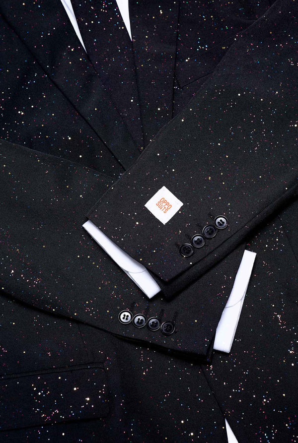 Bild einen OppoSuits Glitzy Glitter-Herrenanzug mit Glitzer und weißem Herrenhemd trägt. Der Anzug besteht aus Hose, Jackett und Krawatte.