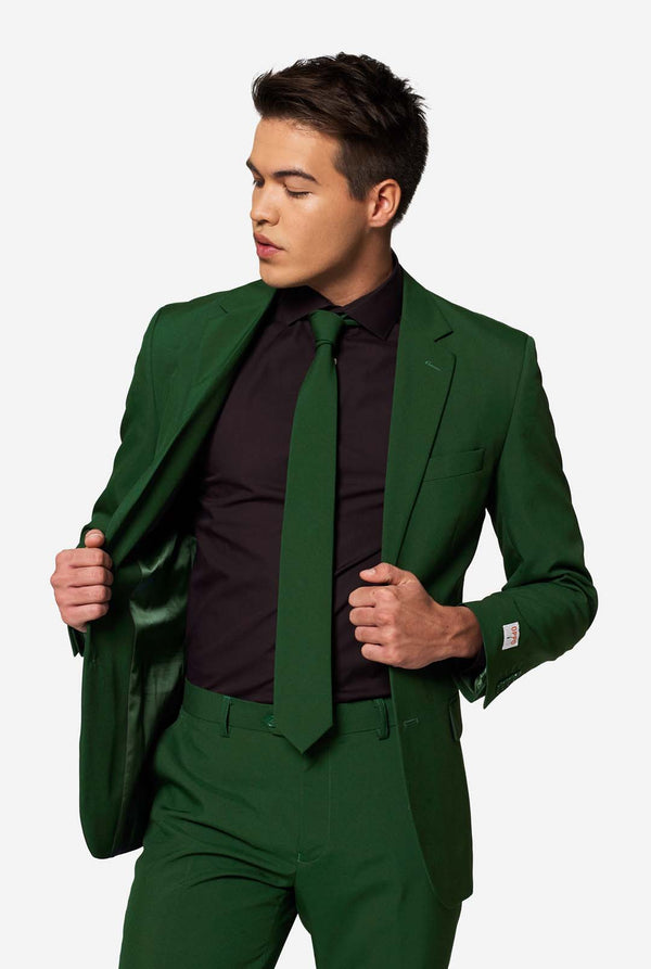 Model präsentiert das Innenfutter des Anzugsjacketts „Glorious Green“ von OppoSuits, kombiniert mit schwarzem Hemd und grüner Krawatte – trendige Herrenmode.