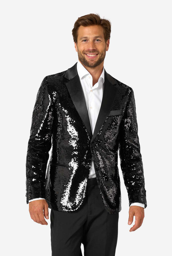 Ein Mann trägt einen schwarzen, mit Pailletten besetzten Blazer mit Schalkragen aus Satin.