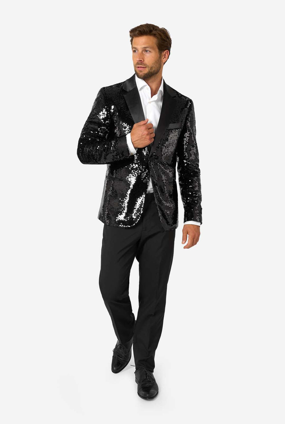 Ein Mann trägt einen schwarzen, mit Pailletten besetzten Blazer mit Schalkragen aus Satin.