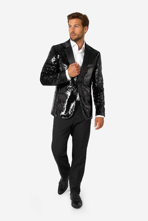 Ein Mann trägt einen schwarzen, mit Pailletten besetzten Blazer mit Schalkragen aus Satin.