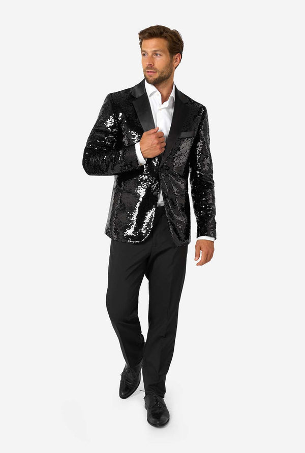 Ein Mann trägt einen schwarzen, mit Pailletten besetzten Blazer mit Schalkragen aus Satin.