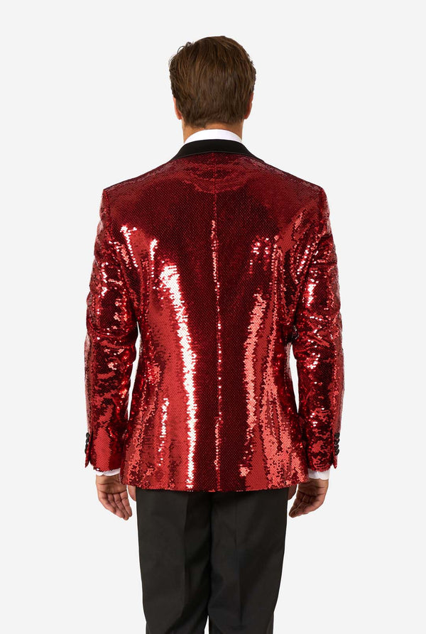 Ein Mann trägt einen glänzenden, roten Blazer mit Pailletten und schwarzen Kragen.