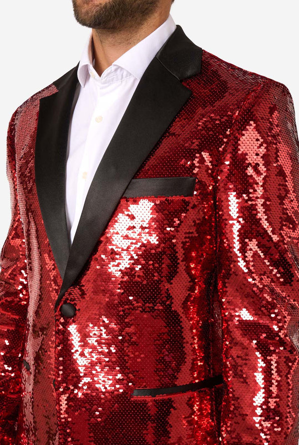 Ein Mann trägt einen glänzenden, roten Blazer mit Pailletten und schwarzen Kragen.