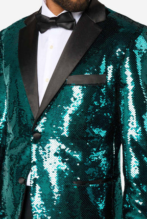 Ein Mann trägt einen türkis-glitzernden Blazer mit schwarzem Satin-Kragen.