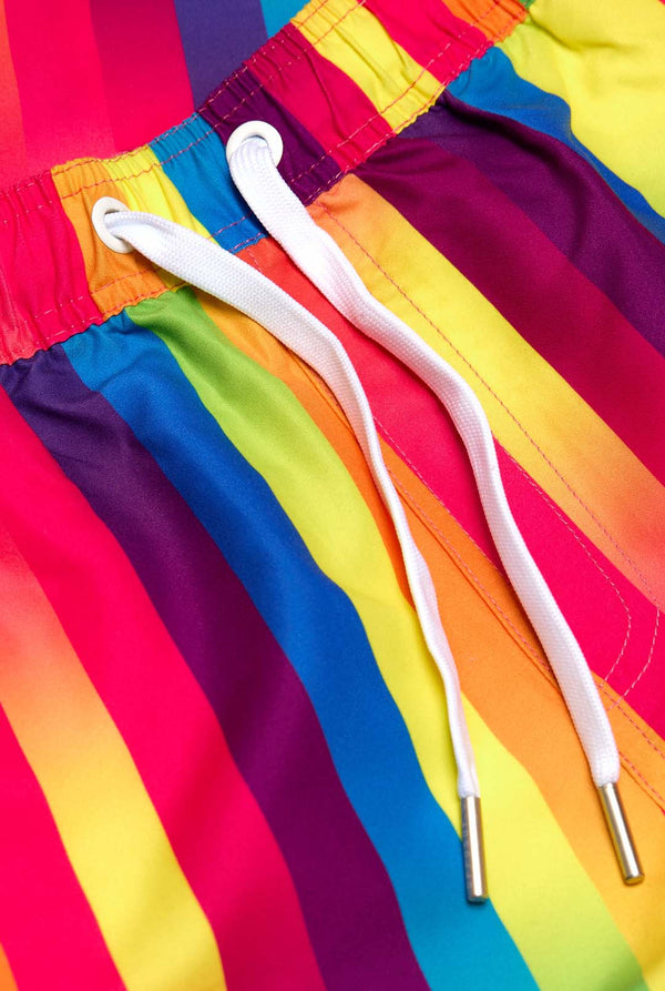 Bild eines vertikal gestreiften Sommersets in Regenbogenfarben, bestehend aus Hemd und Shorts. Nahaufnahme der Shorts.