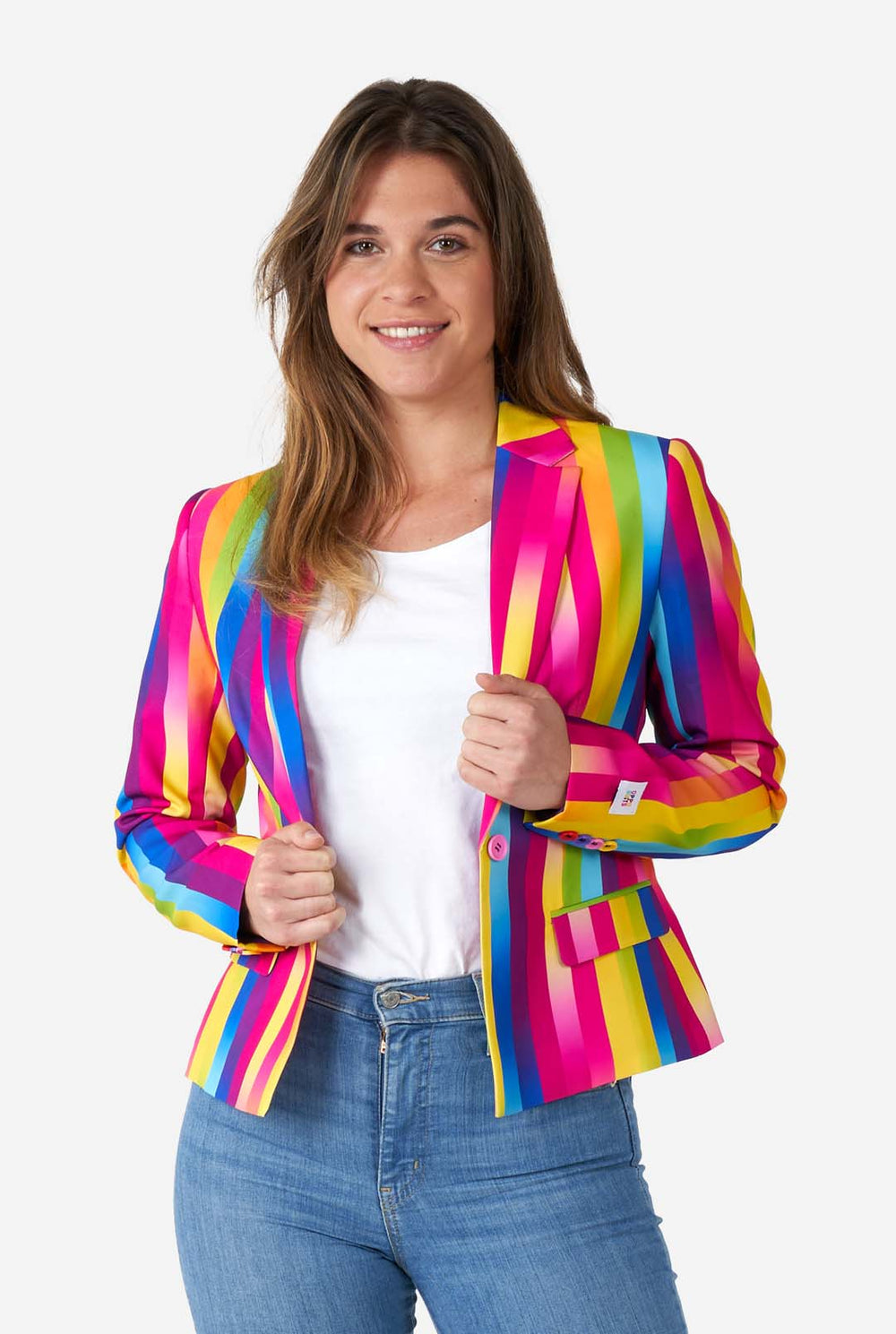 Bild einer Frau, die einen vertikal gestreiften Damenblazer in Regenbogenfarben, ein weißes Hemd und blaue Jeans trägt. Sie hält die Seiten des Blazers.