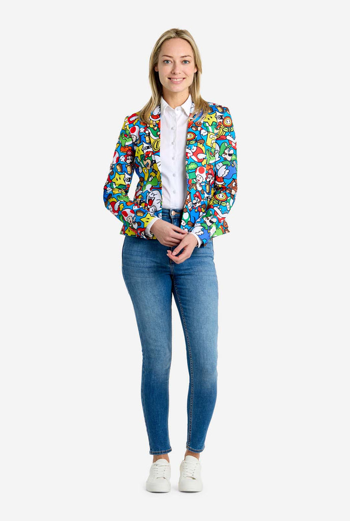 Frau trägt einen Super Mario-Blazer mit Allover-Print und ikonischen Super Mario-Figuren. Die Basis ist hellblau, aber es gibt auch Gelb, Rot und Weiß.