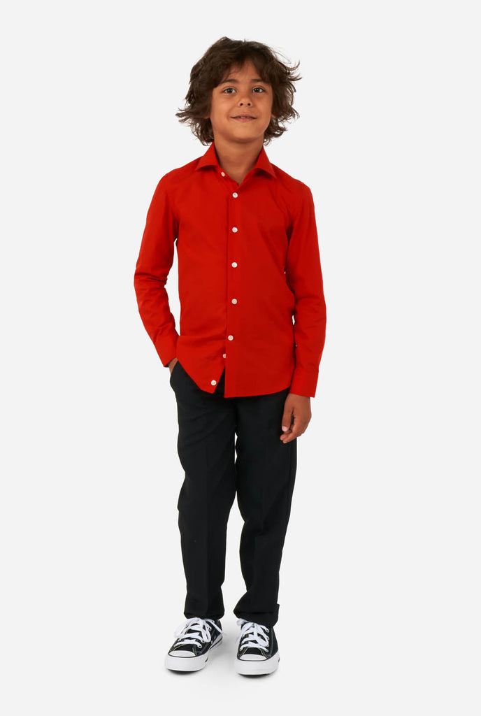 Jongen draagt rood overhemd en zwarte broek