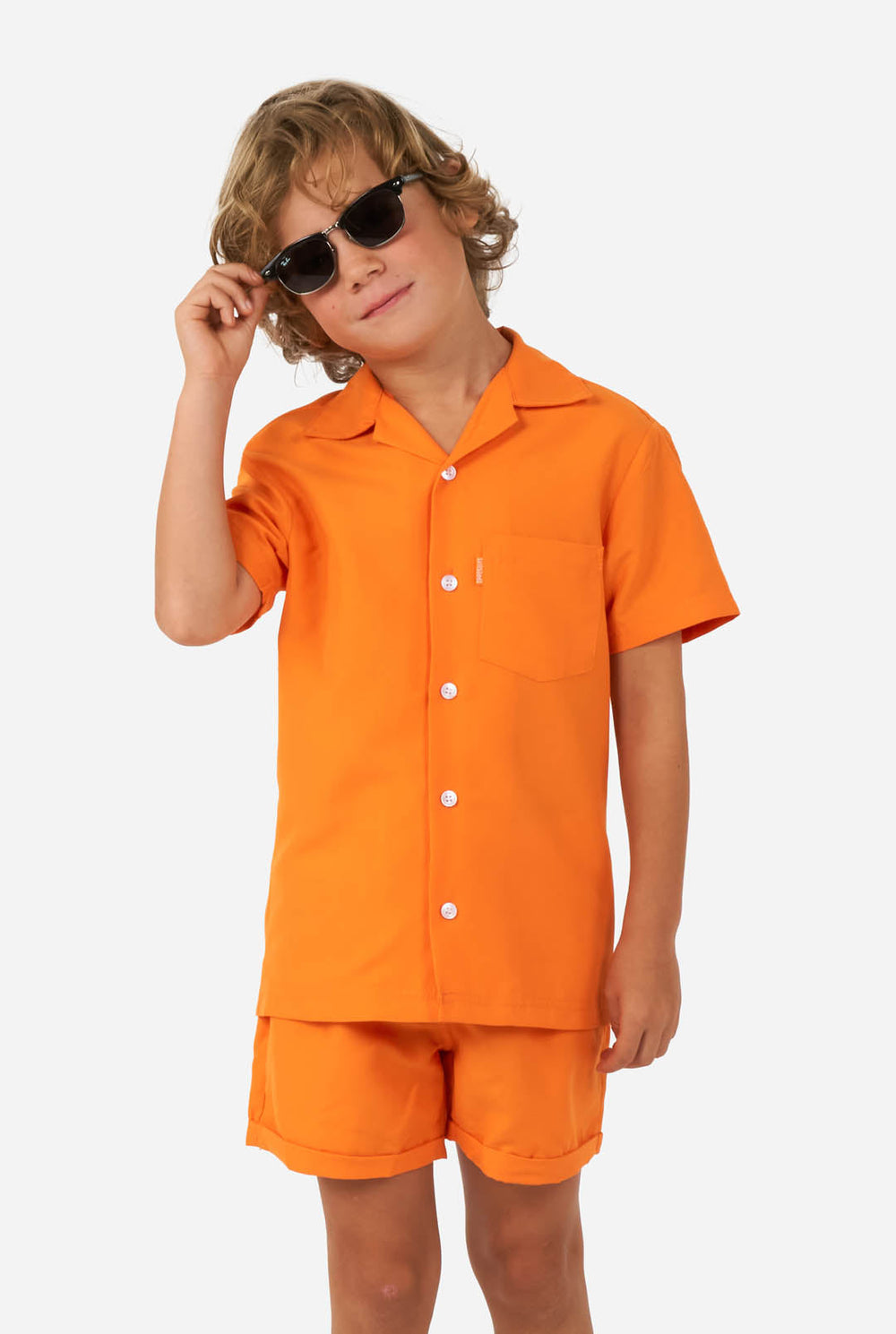 Junge trägt orange Sommerset, bestehend aus Shorts und Shirt