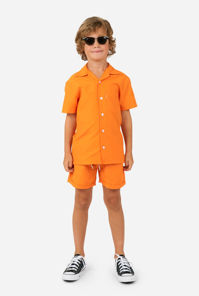 Jongen draagt oranje zomerset, bestaande uit korte broek en shirt