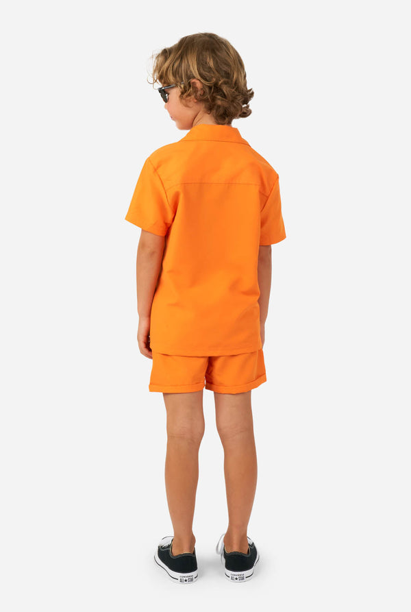Junge trägt orange Sommerset, bestehend aus Shorts und Shirt
