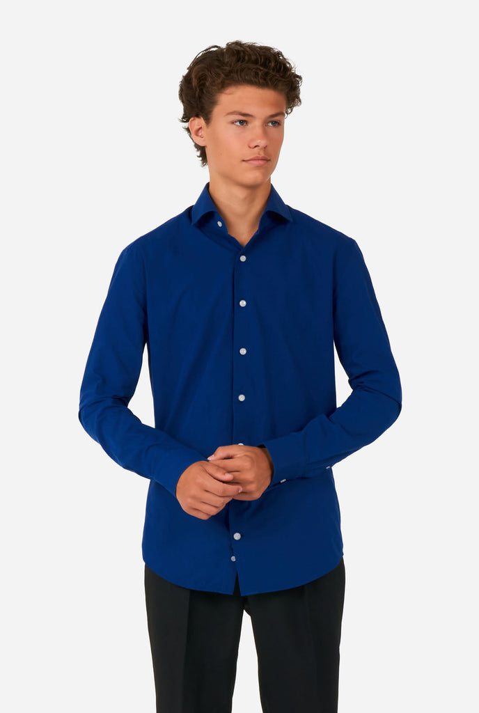 Tiener draagt blauw overhemd en zwarte broek