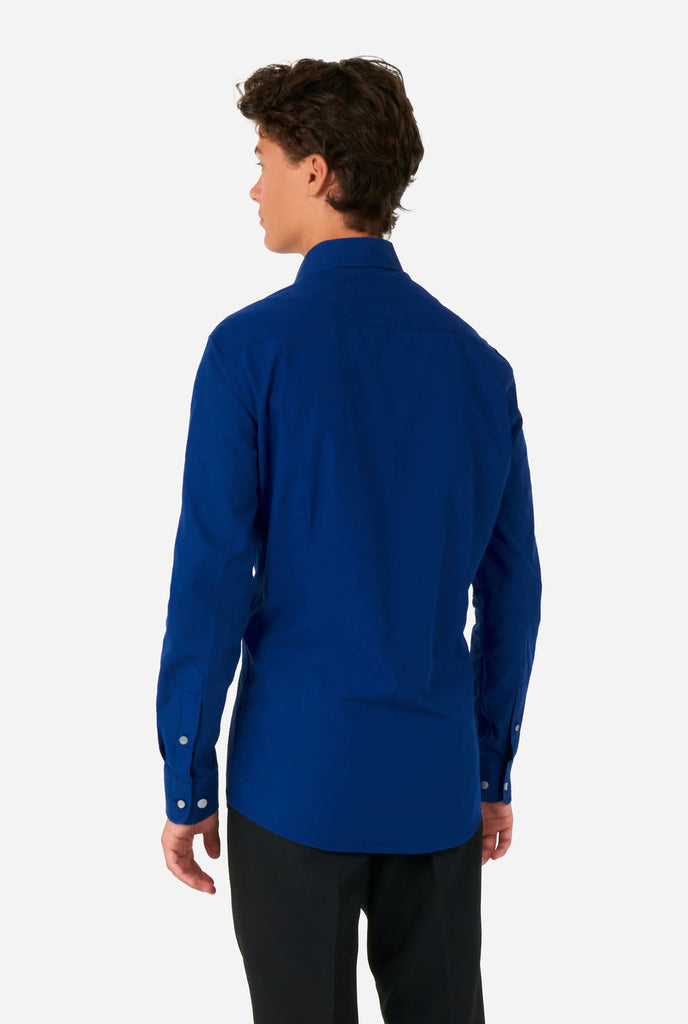 Tiener draagt blauw overhemd en zwarte broek, zicht van de achterkant