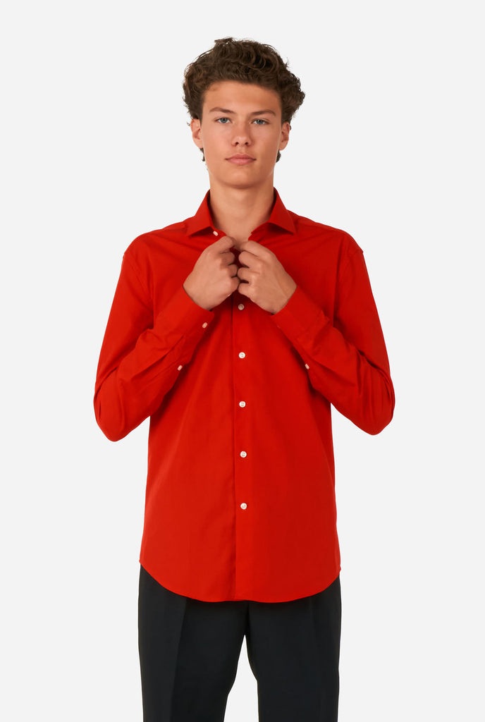 Tiener draagt rood overhemd en zwarte broek