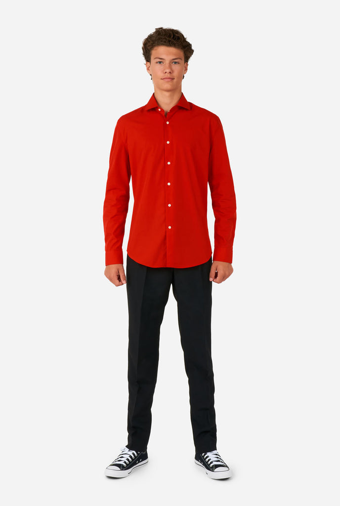 Tiener draagt rood overhemd en zwarte broek