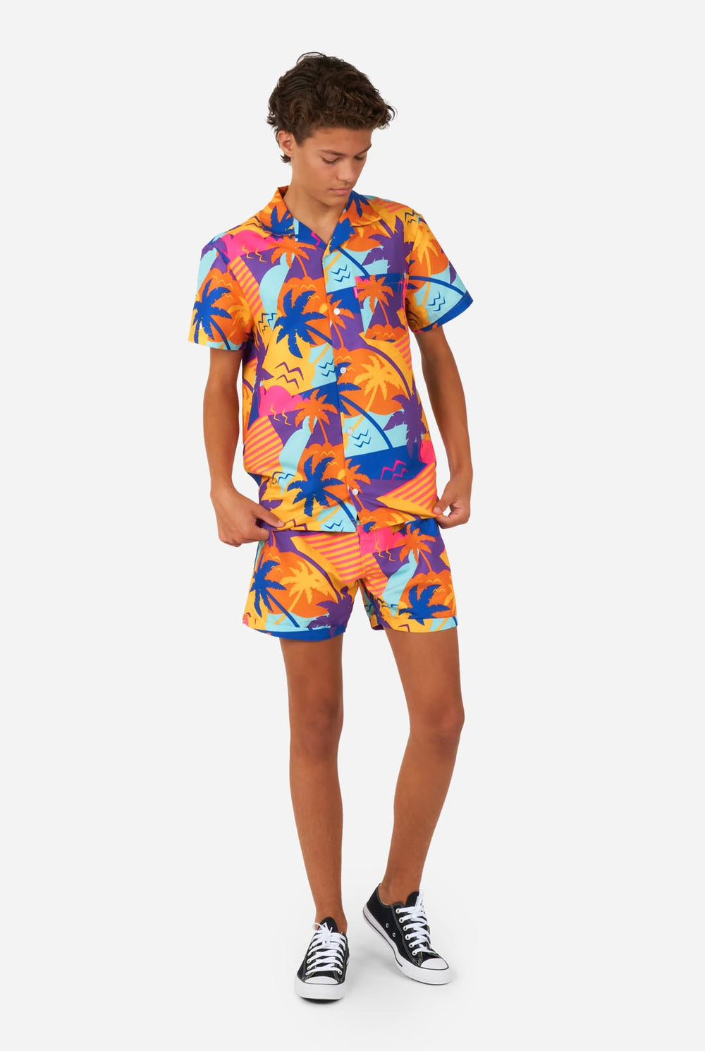 Teenager trägt buntes Palmen-Sommerset, bestehend aus Shirt und Shorts.