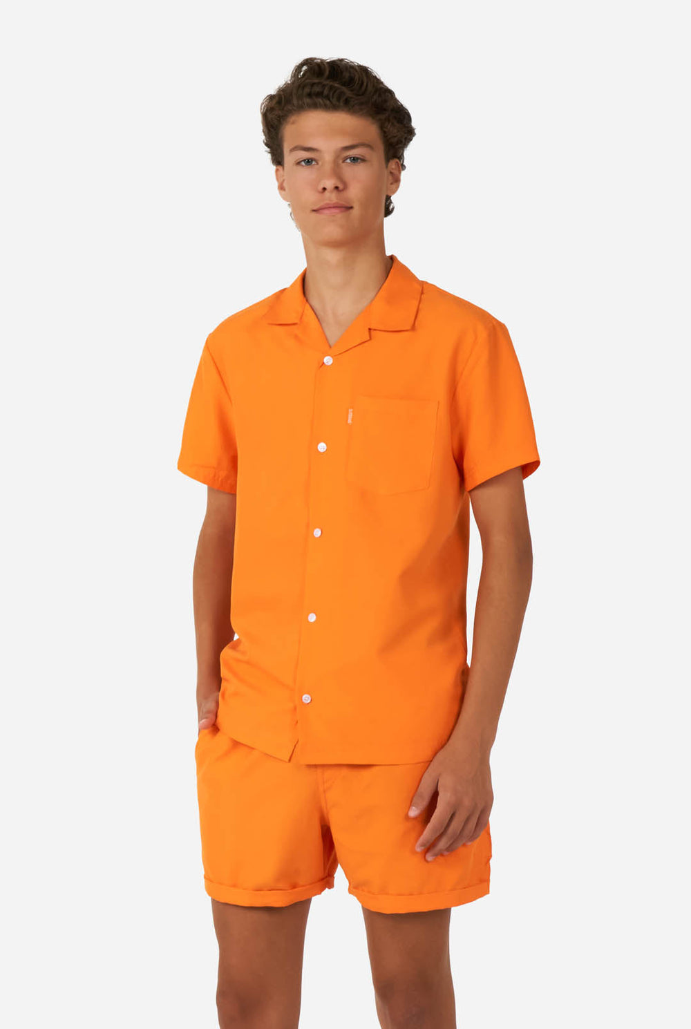 Teenager trägt orangefarbenes Sommerset, bestehend aus Shirt und Shorts.