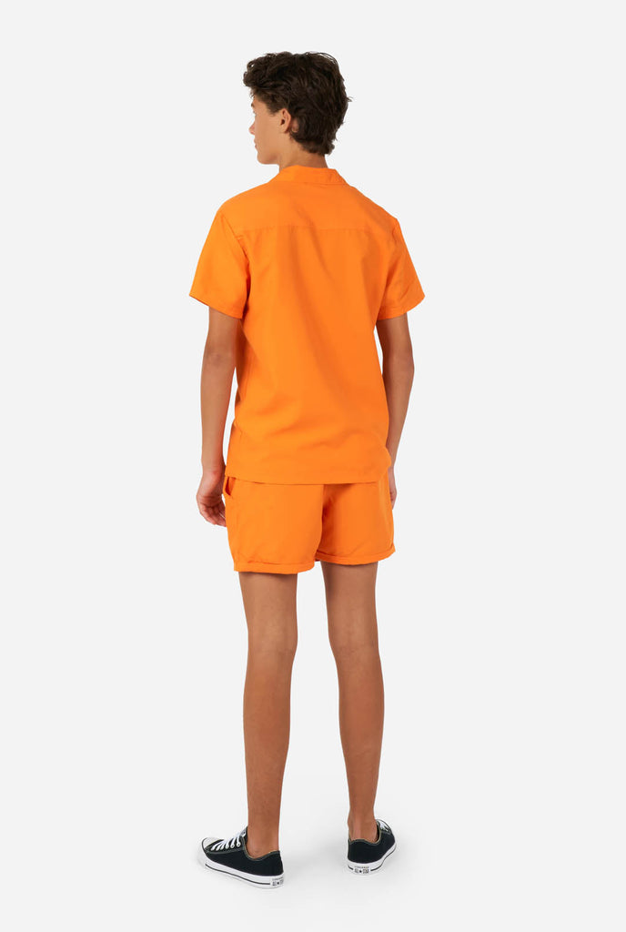 Tiener draagt oranje zomerset, bestaande uit shirt en short.