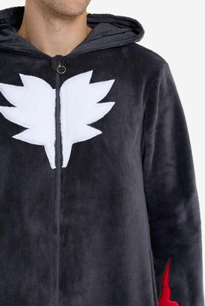 Ein Mann trägt einen plüschigen schwarzen Onesie, inspiriert vom beliebten Igel Shadow. Mit stacheligen roten und schwarzen Akzenten an der Kapuze, einem weißen Brustemblem und gelben Handgelenksdetails. Der Onesie aus weichem Fleece bietet Komfort und ein verspieltes Design für Cosplay, zum Entspannen oder für Themenveranstaltungen. Brust-Nahaufnahme. Perfekt für Fans von Gaming- oder Zeichentrickfiguren.