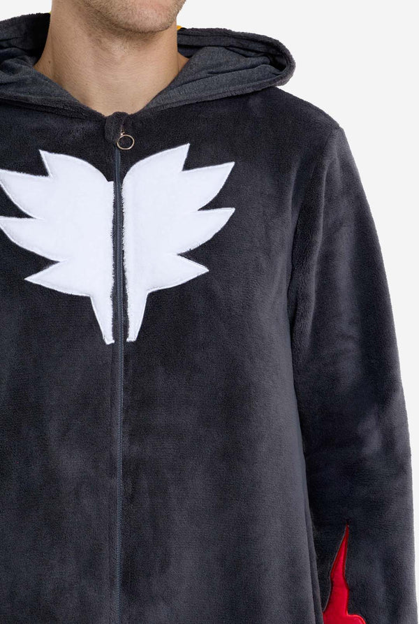 Ein Mann trägt einen plüschigen schwarzen Onesie, inspiriert vom beliebten Igel Shadow. Mit stacheligen roten und schwarzen Akzenten an der Kapuze, einem weißen Brustemblem und gelben Handgelenksdetails. Der Onesie aus weichem Fleece bietet Komfort und ein verspieltes Design für Cosplay, zum Entspannen oder für Themenveranstaltungen. Brust-Nahaufnahme. Perfekt für Fans von Gaming- oder Zeichentrickfiguren.