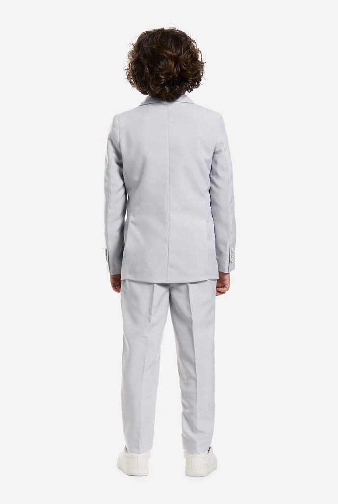Auf diesem Bild trägt ein Kind einen grauen formellen Jungenanzug mit passender Krawatte und einem weißen Hemd. Der Anzug besteht aus einer Jacke, einer Hose und einer Krawatte zum Anstecken.