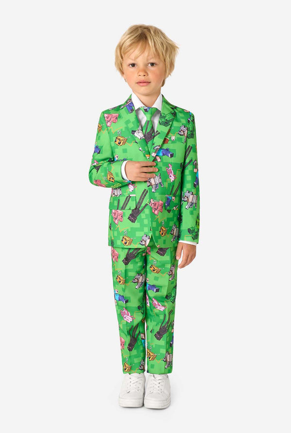 Ganzkörperbild eines Kindes in einem grünen Minecraft-Anzug von OppoSuits, der lächelt und selbstbewusst posiert.