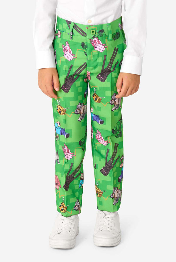 Nahaufnahme einer Minecraft-Anzughose mit Creepers, Schweinen und Wölfen in einem Pixel-Print, getragen von einem Kind.