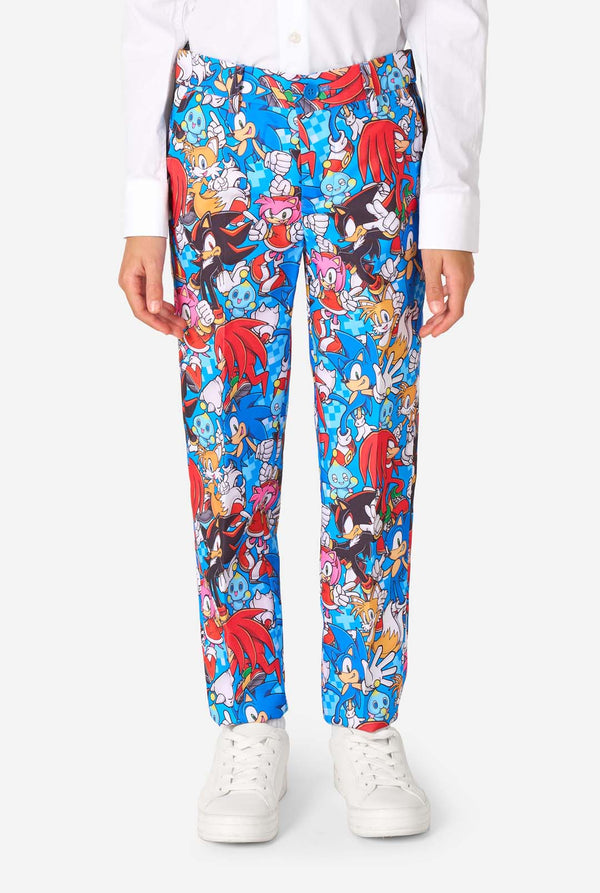 Junge in einem farbenfrohen Sonic-Teenie-Anzug mit bunten Aufdrucken von Sonic the Hedgehog-Figuren wie Sonic, Knuckles, Tails und Amy, gepaart mit einer passenden Krawatte und einem weißen Hemd. Nahaufnahme Hose.