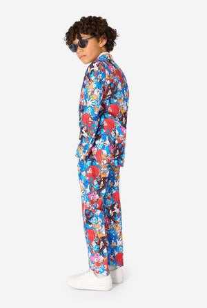 Junge mit Sonnenbrille und einem farbenfrohen Sonic-Teenie-Anzug mit bunten Aufdrucken von Sonic the Hedgehog-Figuren wie Sonic, Knuckles, Tails und Amy, gepaart mit einer passenden Krawatte und einem weißen Hemd. Seitenansicht.