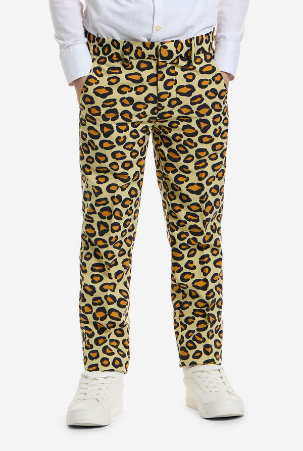 Auf diesem Bild trägt ein Kind einen Jungenanzug mit Panther-Allover-Print und weißem Hemd. Der Anzug ist beige mit braun-schwarz geflecktem Panther-Print. Der Anzug besteht aus Jacke, Hose und Clip-On-Krawatte.