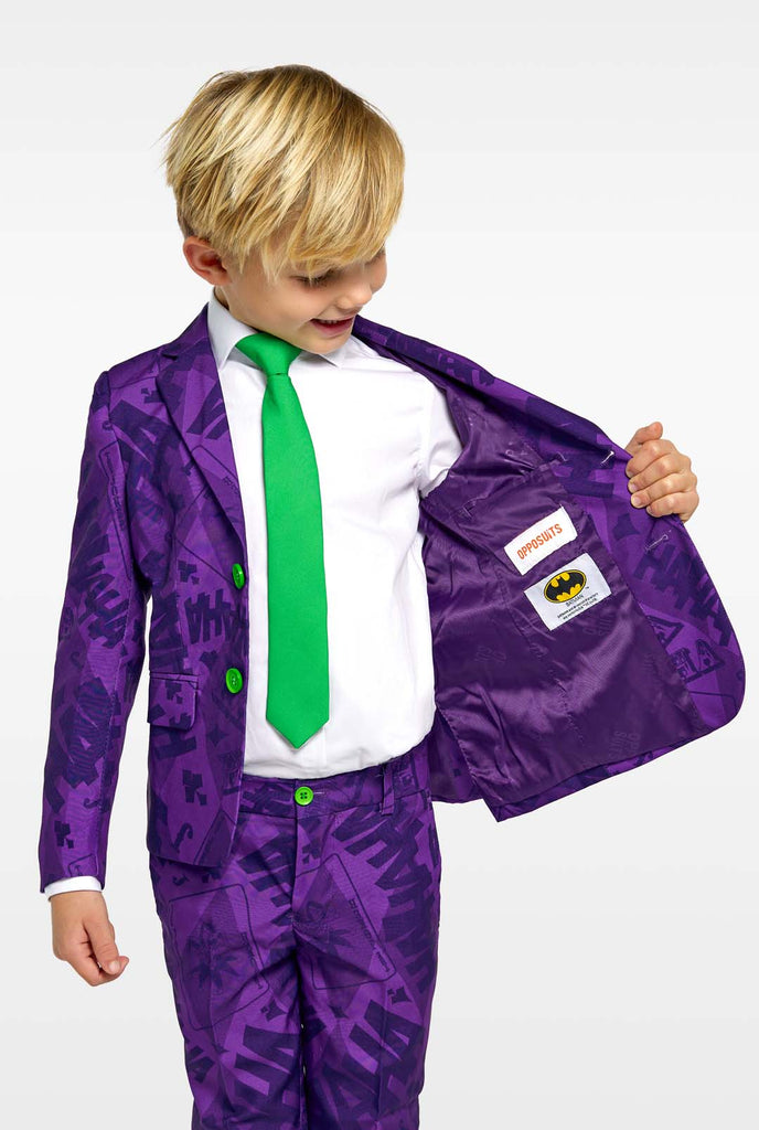 Kind trägt lila Jungenanzüge mit dem Joker-Batman-Thema