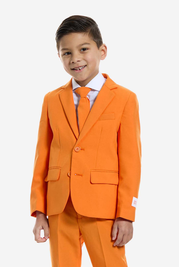 Kind trägt einen orangefarbenen Anzug von OppoSuits.