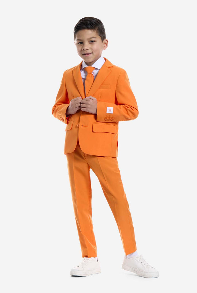 Kind trägt einen orangefarbenen Anzug von OppoSuits.