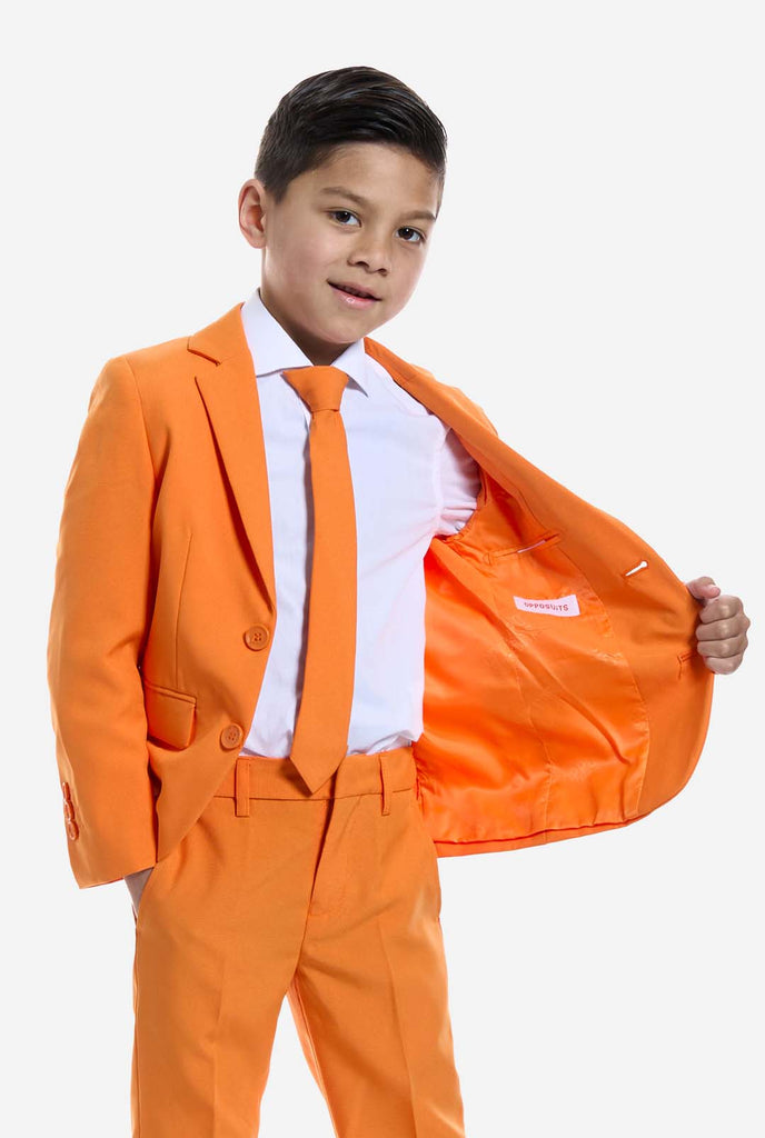 Kind trägt einen orangefarbenen Anzug von OppoSuits.